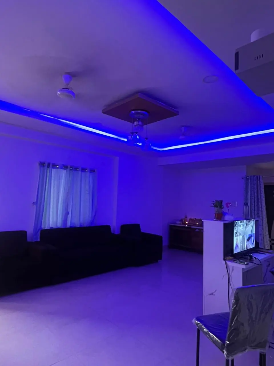 The waiting lounge in the evening, with sofas, the front desk and blue cove lighting